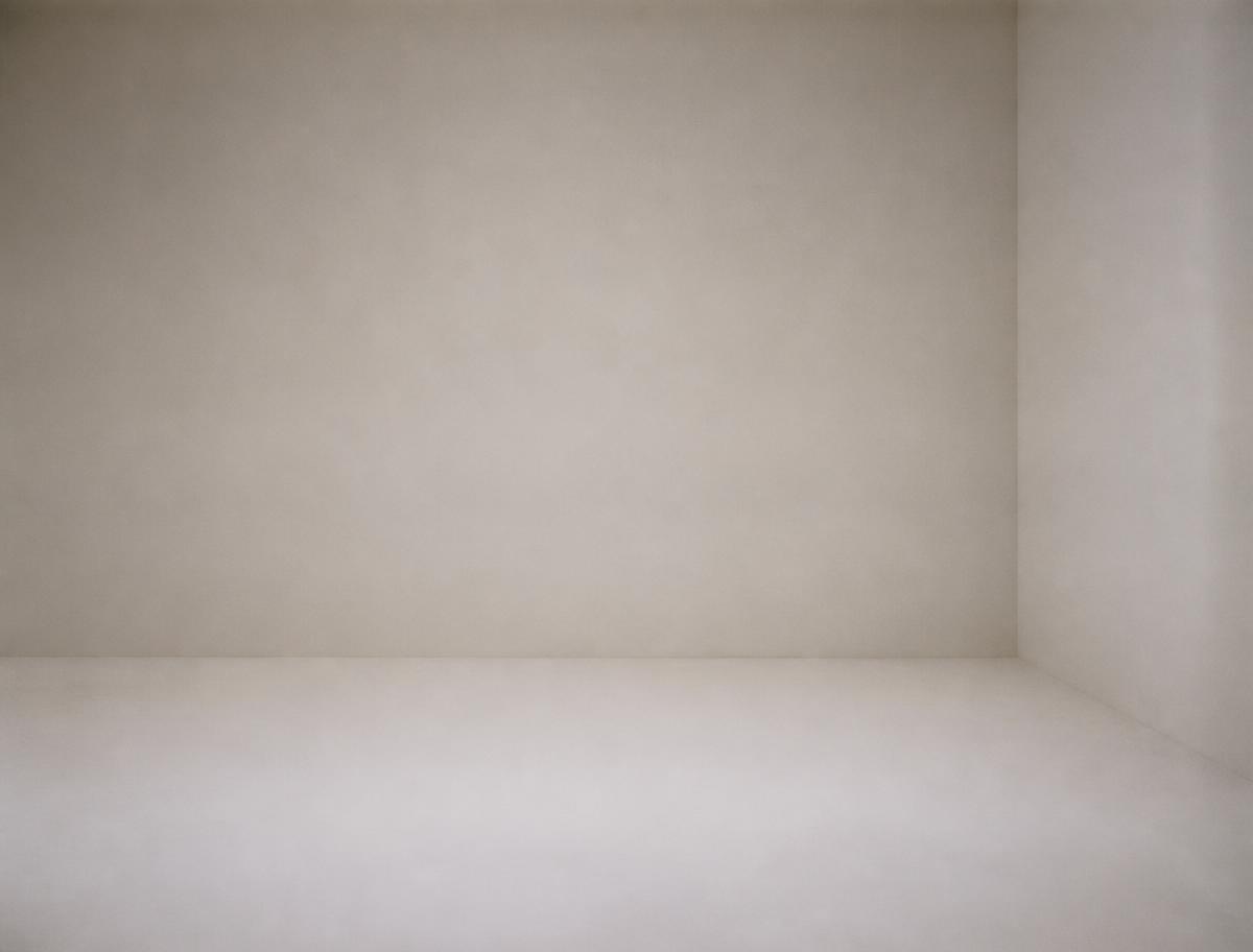 Espace entièrement vide, murs de papier blanc cassé et lumière douce.